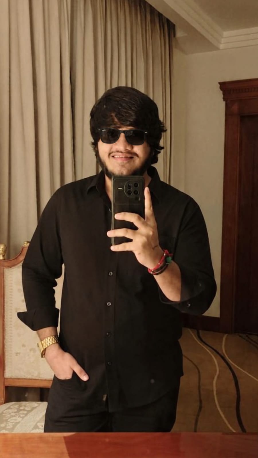 Mirror portrait of Meet Rafaliya in a black shirt with sunglasses